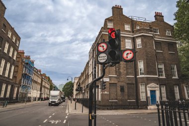 Londra 'da kırmızı ışık ve bisiklet dışında giriş olmadığını gösteren işaretler olan bir cadde. Yol klasik binalarla dolu ve sokakta bir teslimat kamyonu görülüyor..