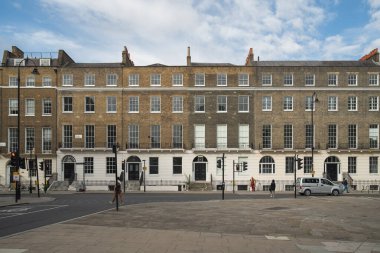 Londra, İngiltere, 11 Temmuz 2023, Geleneksel Teras Hattı Yeşil Ağaçlı Sessiz Sokak ve Mahallenin Sakin Atmosferini Yansıtan Kızıl Londra Otobüsü.
