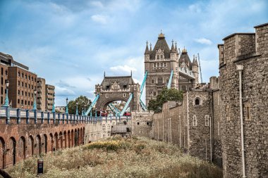Kule Köprüsü, Londra Kulesi 'nin yıpranmış taş duvarlarının arkasında yükseliyor. Geçmişten günümüze ufuk çizgisine bağlanıyor..