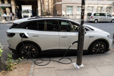 Londra, İngiltere, 11 Temmuz 2023, Şehir Caddesinde EV şarj noktası olarak kullanılan sokak lambasına bağlı elektrikli araba şarjı