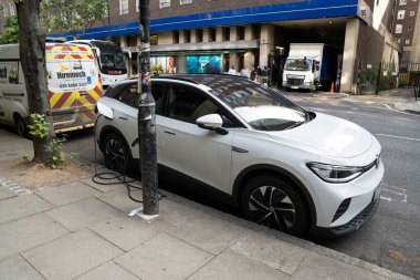 Londra, İngiltere, 11 Temmuz 2023, Şehir Caddesinde EV şarj noktası olarak kullanılan sokak lambasına bağlı elektrikli araba şarjı