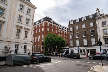 Londra, İngiltere, 11 Temmuz 2023, Barışçıl Sokaklar Geleneksel Tuğla Binalar ve Modern Mimariyle Sıralanmış, Yaprak Altında Sakin Şehir Hayatı Yakalıyor.