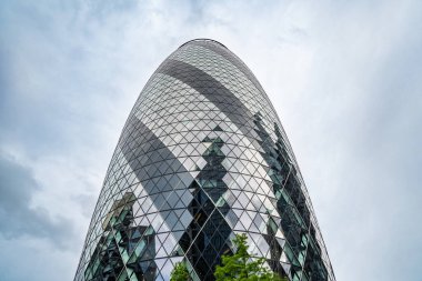 Londra, İngiltere, 11 Temmuz 2023, Iconic Gherkin Tarihi Taş Kilisesi 'nin Arkasında Yükseliyor, Londonların Modern ve Geleneksel Mimarinin Finansal Bölgede Çarpıcı Harmanını Gösteriyor. 