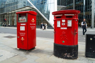 Londra, İngiltere, 11 Temmuz 2023, Klasik ve Modern Kırmızı Kraliyet Posta Kutuları Gelenek ve Yeniliğin Şehir Harmanını Yansıtarak Yan yana Duruyor.