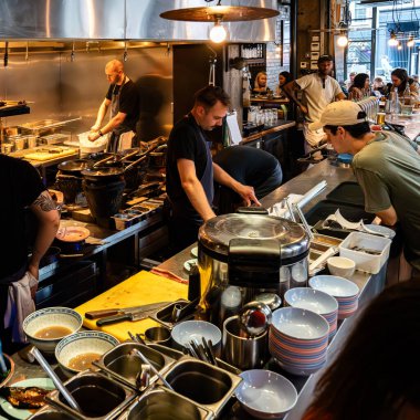 Londra, İngiltere, 11 Temmuz 2023, Londra 'da Bustling Thai Lokantası, Açık Mutfakta Lokantalar ve Aşçılar, Şehir Endüstrisi Tasarımı Otantik Asya Mutfağı Titreşimleri ile Harmanlanıyor.