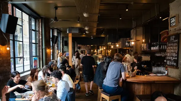 Londra, İngiltere, 11 Temmuz 2023, Londra 'da Bustling Thai Lokantası, Açık Mutfakta Lokantalar ve Aşçılar, Şehir Endüstrisi Tasarımı Otantik Asya Mutfağı Titreşimleri ile Harmanlanıyor.