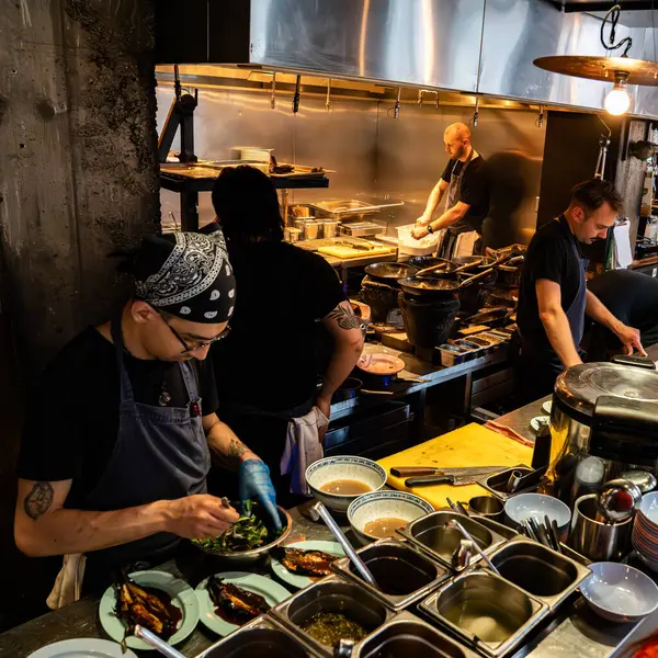 Londra, İngiltere, 11 Temmuz 2023, Londra 'da Bustling Thai Lokantası, Açık Mutfakta Lokantalar ve Aşçılar, Şehir Endüstrisi Tasarımı Otantik Asya Mutfağı Titreşimleri ile Harmanlanıyor.