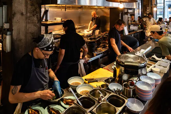 Londra, İngiltere, 11 Temmuz 2023, Londra 'da Bustling Thai Lokantası, Açık Mutfakta Lokantalar ve Aşçılar, Şehir Endüstrisi Tasarımı Otantik Asya Mutfağı Titreşimleri ile Harmanlanıyor.