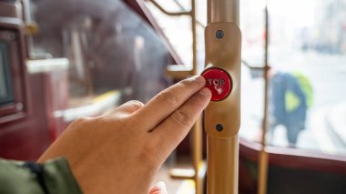 Kırmızı bir Londra otobüsünde dur düğmesine basan bir Yolcu Parmağı Toplu Taşımacılık Deneyimi 'nde Bir Anı Yakalıyor.