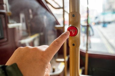 Kırmızı bir Londra otobüsünde dur düğmesine basan bir Yolcu Parmağı Toplu Taşımacılık Deneyimi 'nde Bir Anı Yakalıyor.