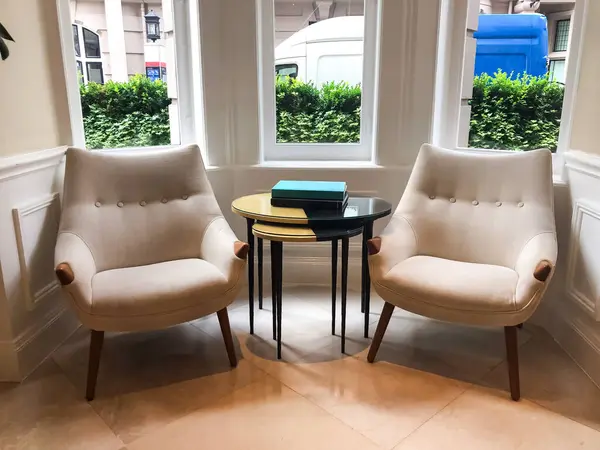 Otel lobisindeki bir sehpanın üzerine yerleştirilmiş bir kitap, sakin ve davetkar bir atmosfer yaratıyor. Yumuşak ışık ve zarif ortam uzayın huzurlu ve rahat atmosferini vurgular..