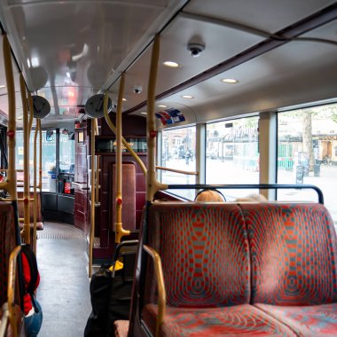 Londra, İngiltere, 12 Temmuz 2023, Boş Koltuklu, Parlak Pencereli ve Şehir Manzaralı Iconic Red-Desenli Koltukları Gösteren, İçi Boş Bir Londra Otobüs Otobüsünün İçi