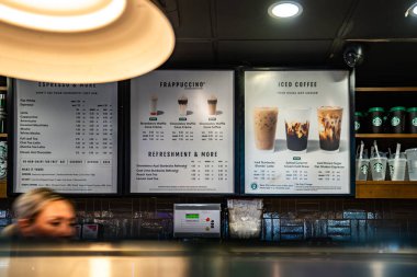Londra, İngiltere, 12 Temmuz 2023, Starbucks Menü Kurulu çeşitli Espresso, Frappuccino ve buzlu kahve içeceklerinin yer aldığı tezgahın arkasında sergilendi..