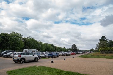 Blenheim Sarayı, Birleşik Krallık - 12 Temmuz 2023, Blenheim Sarayı 'nda park edilmiş araçlarla dolu yoğun bir otopark, insanlar arabalarını yükleyip boşaltırken hareketlilik dolu..