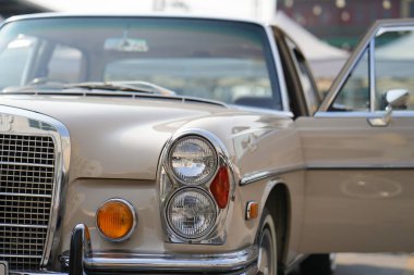 Klasik arabaların yuvarlak farları ve yan dönüş sinyalleri, parlatılmış krom çerçeveli, eski moda aydınlatma ve kıvrımlı çamurluk detaylarıyla vintage tarzı vurgulanıyor.