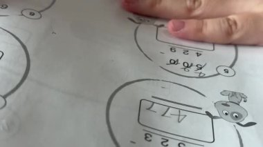 Bangkok, Tayland, 12 Ağustos 2025, masalarında toplanan genç bir öğrenci egzersizleri tamamlıyor, temel matematik ve temel öğrenme becerilerini geliştiriyor..