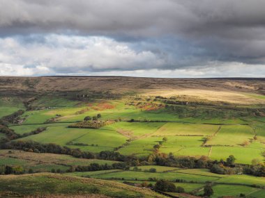 Rosedale Vadisi 'nden uzak Rosedale Ironstone Demiryolu' na ve güneş ışığı tarafından seçilen Doğu Rosedale Madenlerinin kalıntılarına bakın, Kuzey York Moors Ulusal Parkı, İngiltere