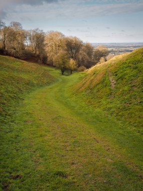 Kingstone Coombes 'dan aşağı yürüyoruz. Buzul Çağı' nda, Ridgeway 'den kurulmuş kuru bir vadi. Ashbury köyü, Oxfordshire, İngiltere' de görülebiliyor.
