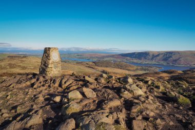 Gowbarrow Fell 'in tepesindeki nirengi sütunu, Ullswater' a bakıyor, Lake District, İngiltere