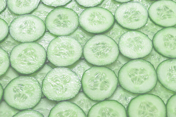 Fresh green slices of cucumber as background. Top view. 