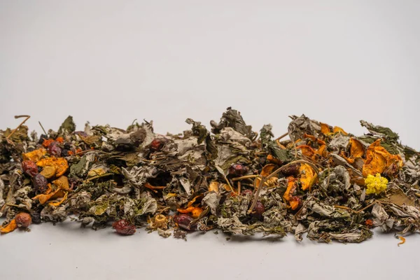 Dry tea leaves and dry fruit isolated on a white background.