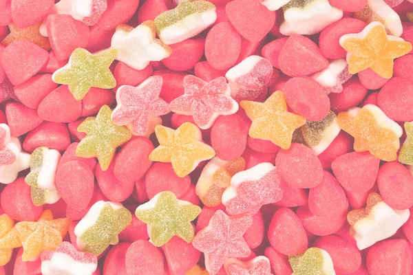Assorted colorful gummy candies and lollipop on red background. Top view. Jelly  sweets.