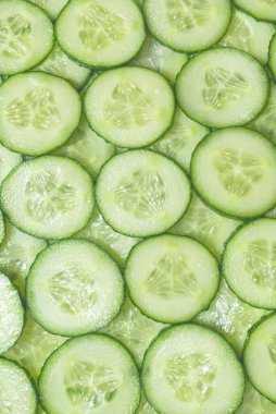 Arka plan olarak taze yeşil salatalık dilimleri. Üst görünüm. 