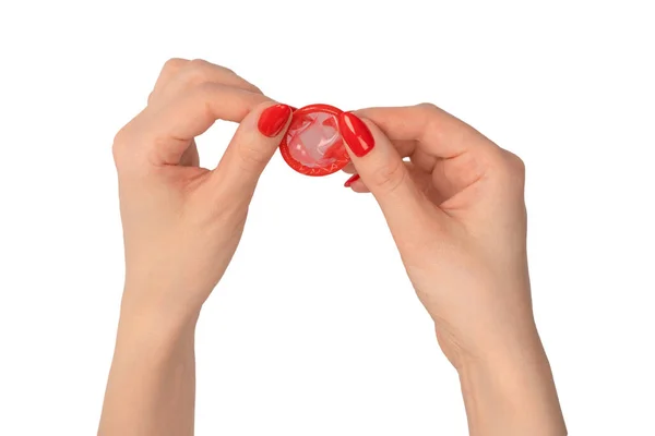 白い背景に赤い爪を持つ女性の手の赤いコンドーム — ストック写真