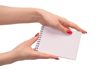 Kırmızı tırnaklı kadınların elinde boş beyaz kağıt olan bir defter. Boşluğu kopyala. 