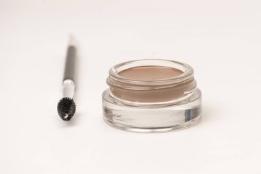 A brow pomade in blonde shade with brush isolated on a white background. Make up. 