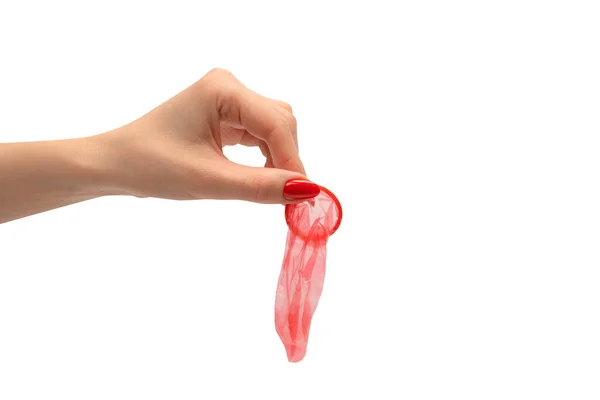 红指甲女人手上的红色避孕套 有红色钉子 背景为白色 — 图库照片