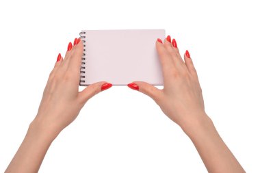 Kırmızı tırnaklı kadınların elinde boş beyaz kağıt olan bir defter. Boşluğu kopyala. 