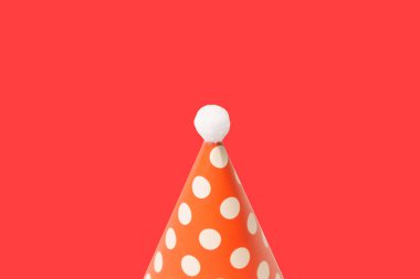 Bright and colorful birthday cap isolated on a red background. Holidays cocept. 