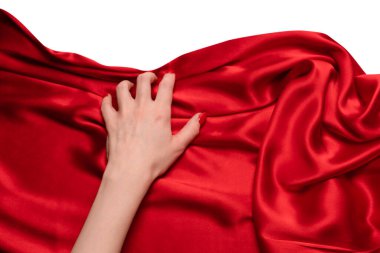 Kırmızı tırnaklı bir kadının eli kırmızı ipek kumaşı yırtmaya çalışıyor.. 