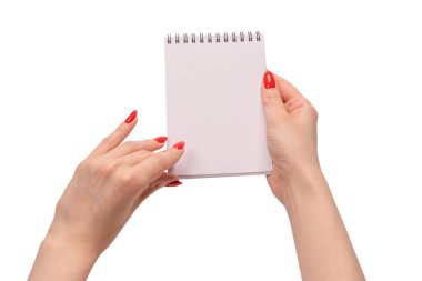 Kırmızı tırnaklı kadınların elinde boş beyaz kağıt olan bir defter. Boşluğu kopyala. 