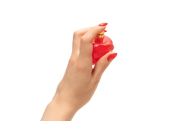 白い背景に隔離された赤い爪を持つ女性の手の香水の赤いボトル 香水の塗布 — ストック写真
