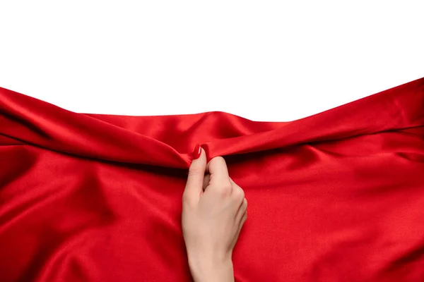 stock image A woman's hand with red nails is trying to rip off  red silk fabric. 