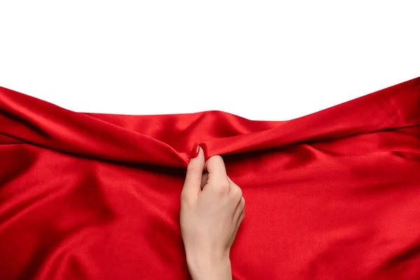 Stock image A woman's hand with red nails is trying to rip off  red silk fabric. 