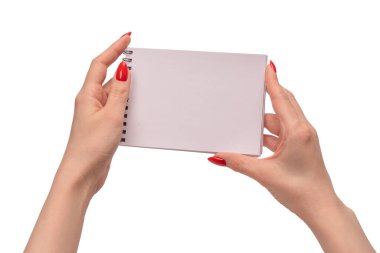Kırmızı tırnaklı kadınların elinde boş beyaz kağıt olan bir defter. Boşluğu kopyala. 