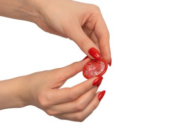 Beyaz arka planda kırmızı tırnaklı bir kadın elinde kırmızı bir prezervatif.. 