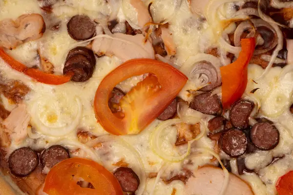 stock image Tasty pizza with salami, sausages, cheese, onions and sauce.