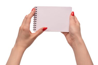 Kırmızı tırnaklı kadınların elinde boş beyaz kağıt olan bir defter. Boşluğu kopyala. 