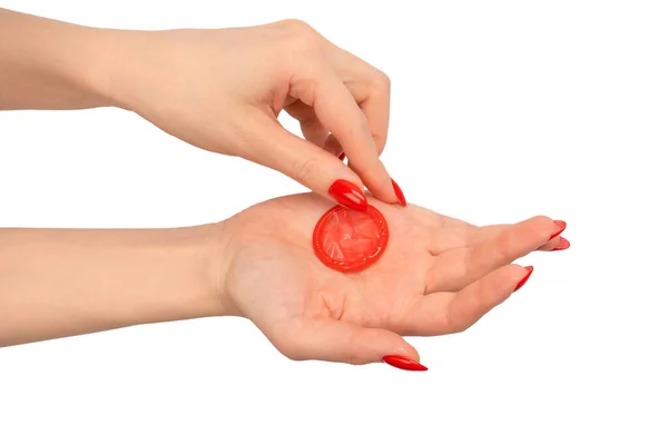 红指甲女人手上的红色避孕套 有红色钉子 背景为白色 — 图库照片