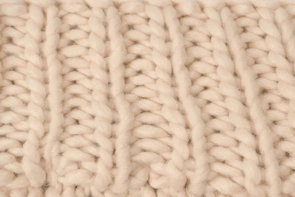 stock image A fragment of beige knitted fabric, knitted from white sheep wool. Knitted background. 