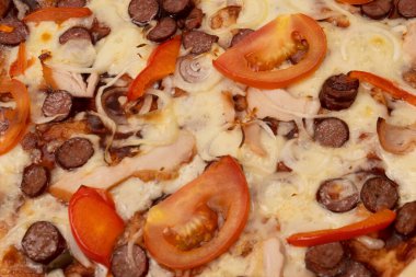 Salamlı, sosisli, peynirli, soğanlı ve soslu lezzetli pizza. Beyaz bir arkaplanda izole edilmiş.