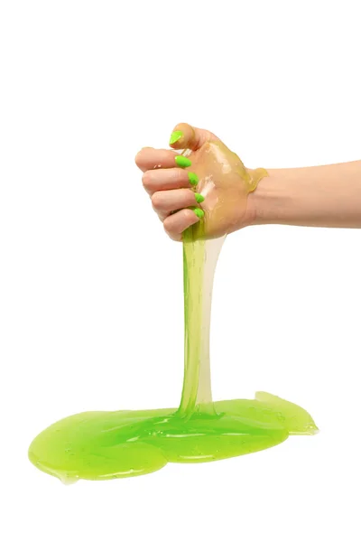 白い背景に隔離された緑の爪を持つ女性の手の中の緑のスライムおもちゃ — ストック写真