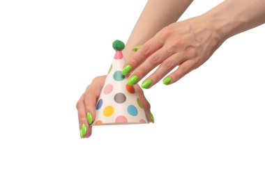 Beyaz arka planda izole edilmiş kadınların ellerinde renkli bir doğum günü şapkası.