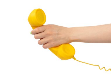 Beyaz arka planda izole edilmiş yeşil tırnaklı kadın eli sarı cep telefonu. Boşluğu kopyala.