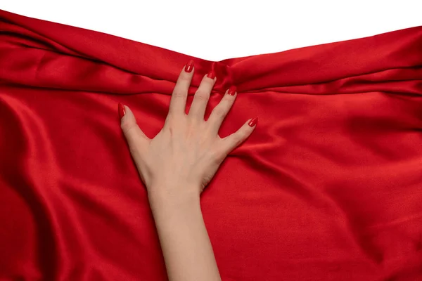 赤い爪を持つ女性の手は赤い絹の生地を破ろうとしている — ストック写真
