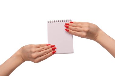 Kırmızı tırnaklı kadınların elinde boş beyaz kağıt olan bir defter. Boşluğu kopyala. 